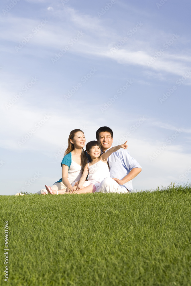 Family of three sitting on the grass Family of three sitting on the grass