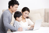 Young family surfing the net with laptop