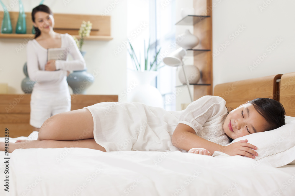 Mother looking at sleeping daughter Mother looking at sleeping daughter