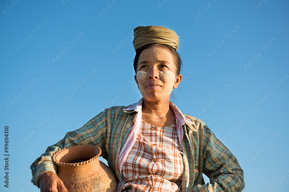 Mature Asian traditional female farmer carrying clay pot Mature Asian traditional female farmer carrying clay pot