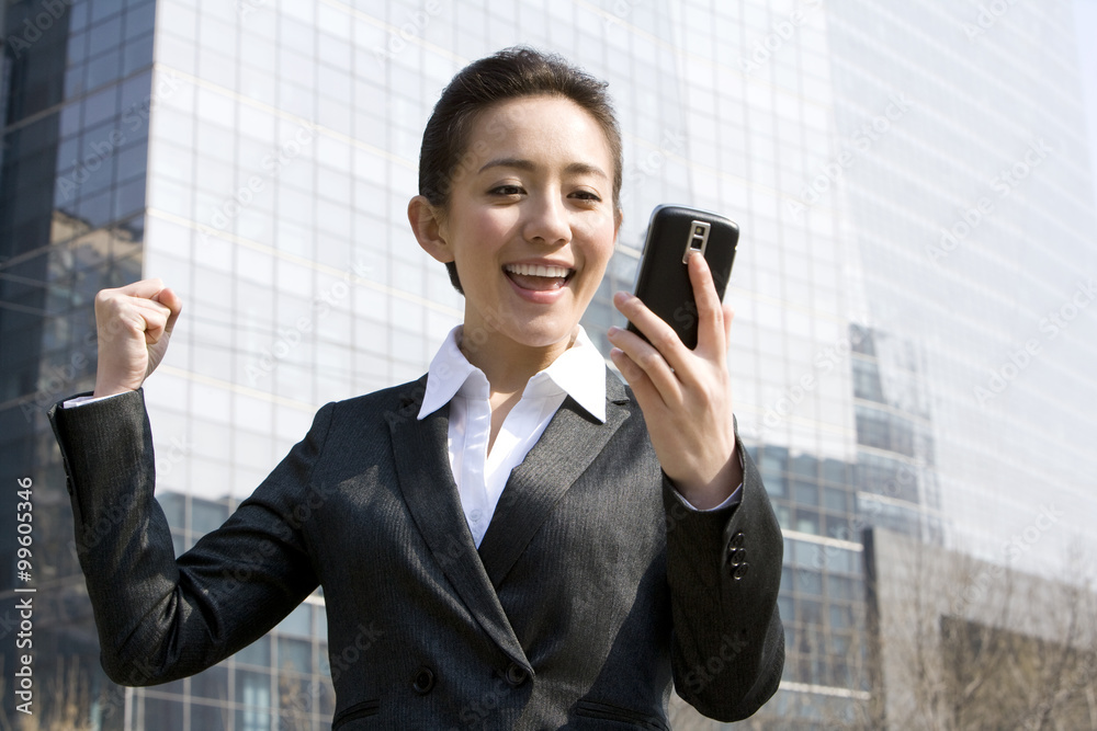 Businesswoman receiving good news on mobile phone Businesswoman receiving good news on mobile phone