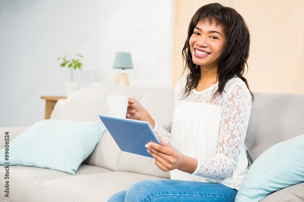 Casual smiling woman using tablet on the couch Casual smiling woman using tablet on the couch