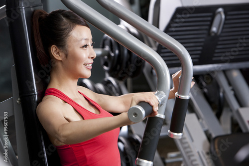 Young Woman Using Exercise Machine