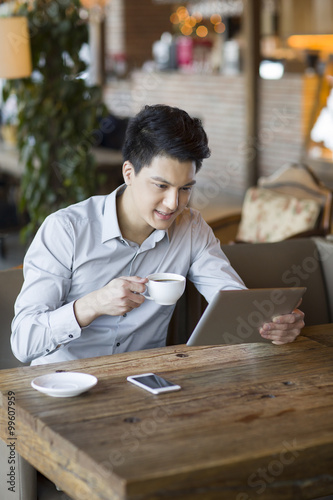 Young man using digital tablet in cafe