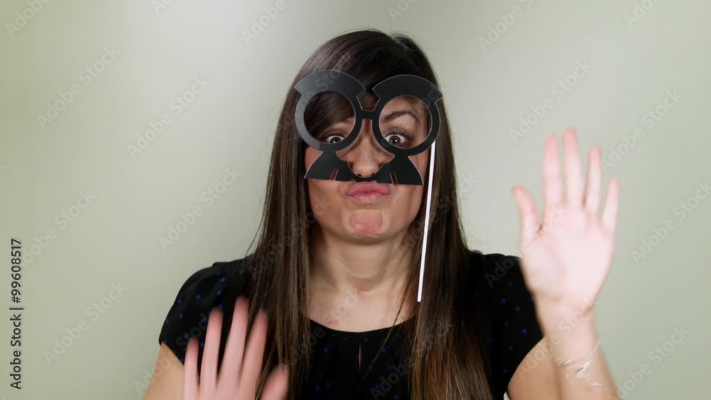 Beautiful girl playing with toy glasses and mustaches. It's carnival Beautiful girl playing with toy glasses and mustaches. It's carnival