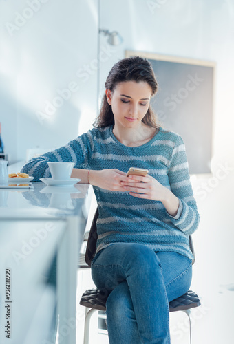 Teenager girl at the bar texting with her mobile