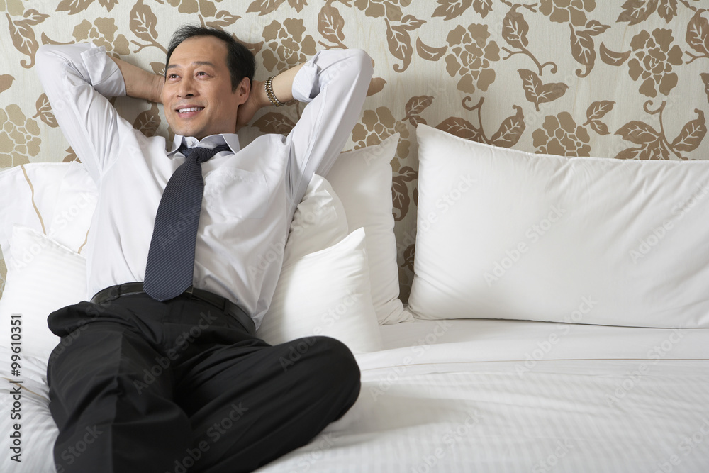 Man in business attire relaxing in bed Man in business attire relaxing in bed