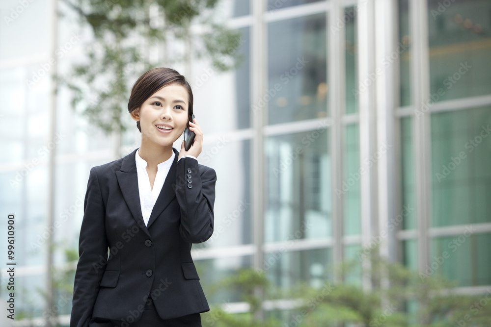 Merry businesswoman on the phone outside a building, Hong Kong Merry businesswoman on the phone outside a building, Hong Kong