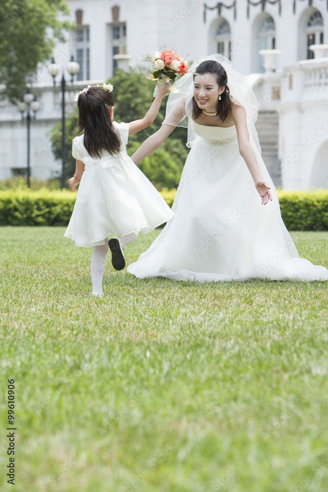 A young flower girl with the bride after a wedding A young flower girl with the bride after a wedding