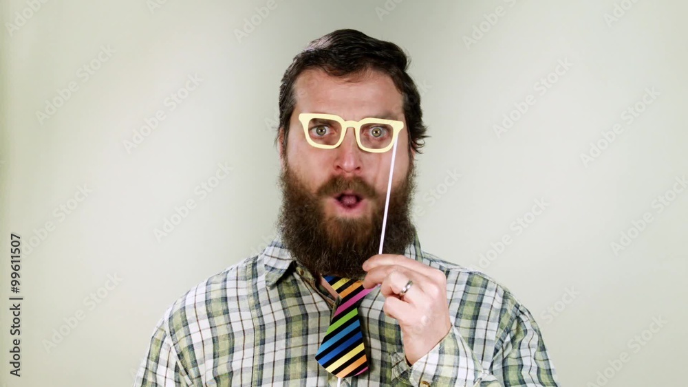 Funny hipster man playing with toy glasses and necktie. It's carnival Funny hipster man playing with toy glasses and necktie. It's carnival