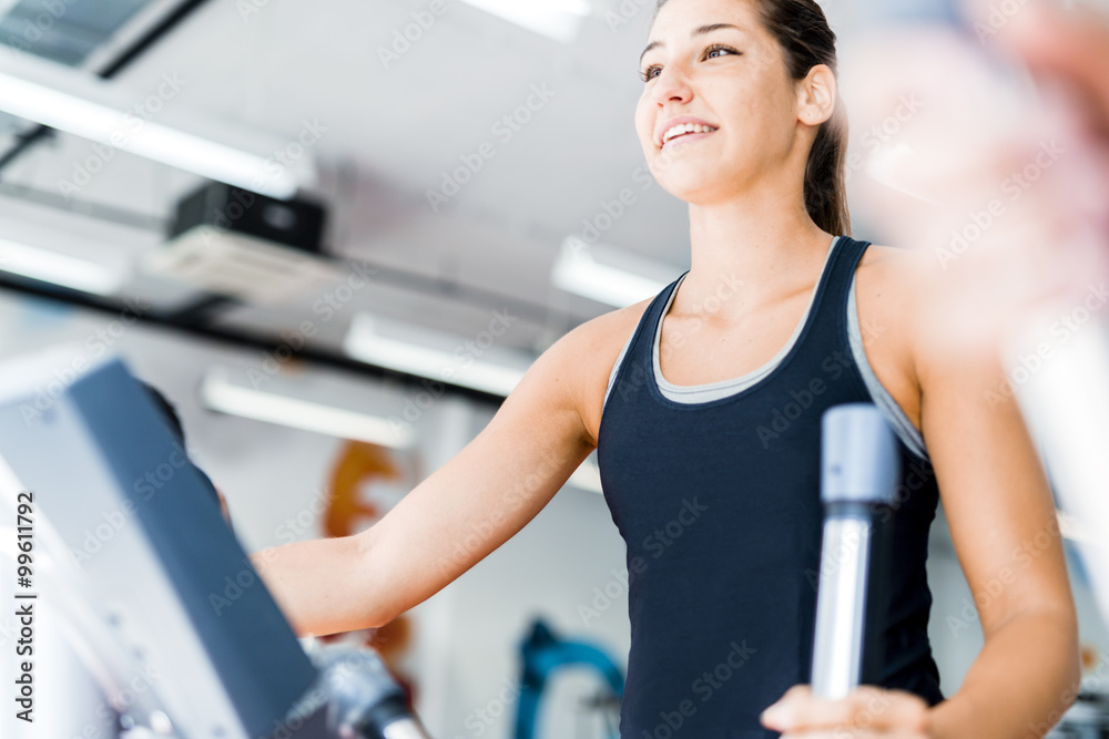 Beautiful young lady using the elliptical trainer Beautiful young lady using the elliptical trainer
