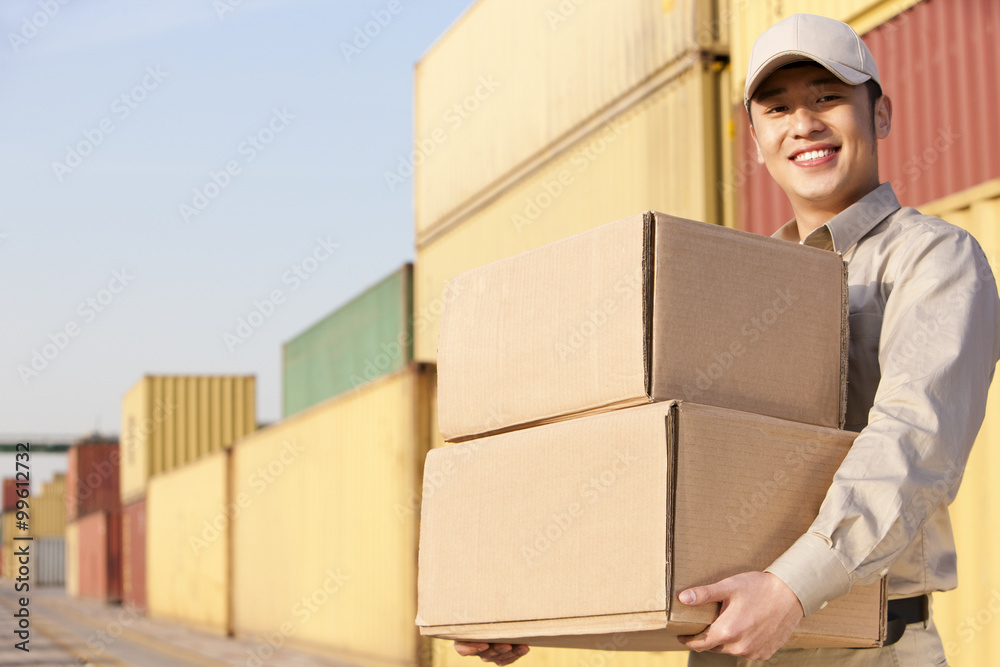 shipping industry worker carrying cardboard boxes shipping industry worker carrying cardboard boxes
