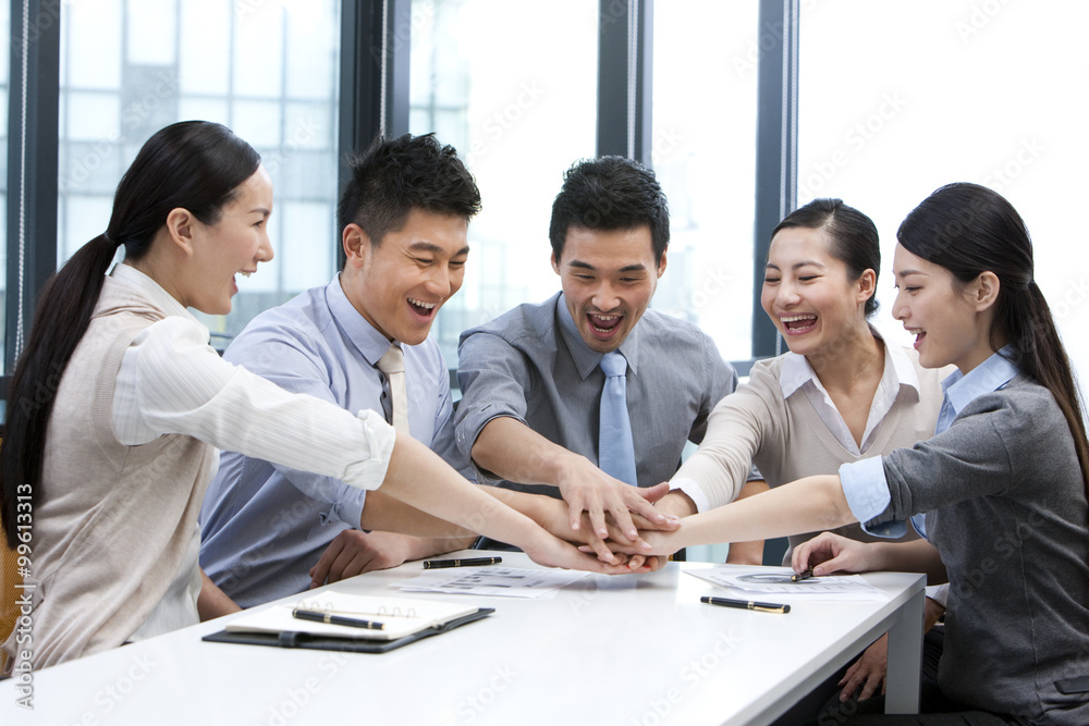 Businesspeople putting their hands in the middle Businesspeople putting their hands in the middle