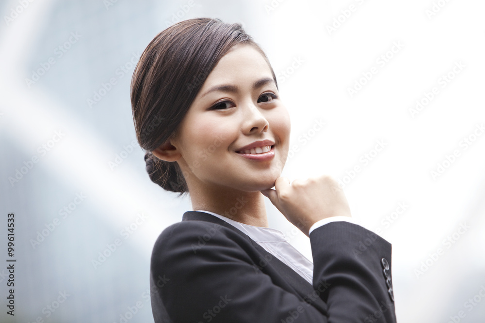 Happy businesswoman looking at camera with hand on chin, Hong Kong Happy businesswoman looking at camera with hand on chin, Hong Kong