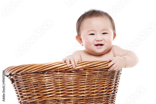 Happy baby girl in a bamboo basket