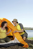 Young Couple Setting Up A Tent While Camping