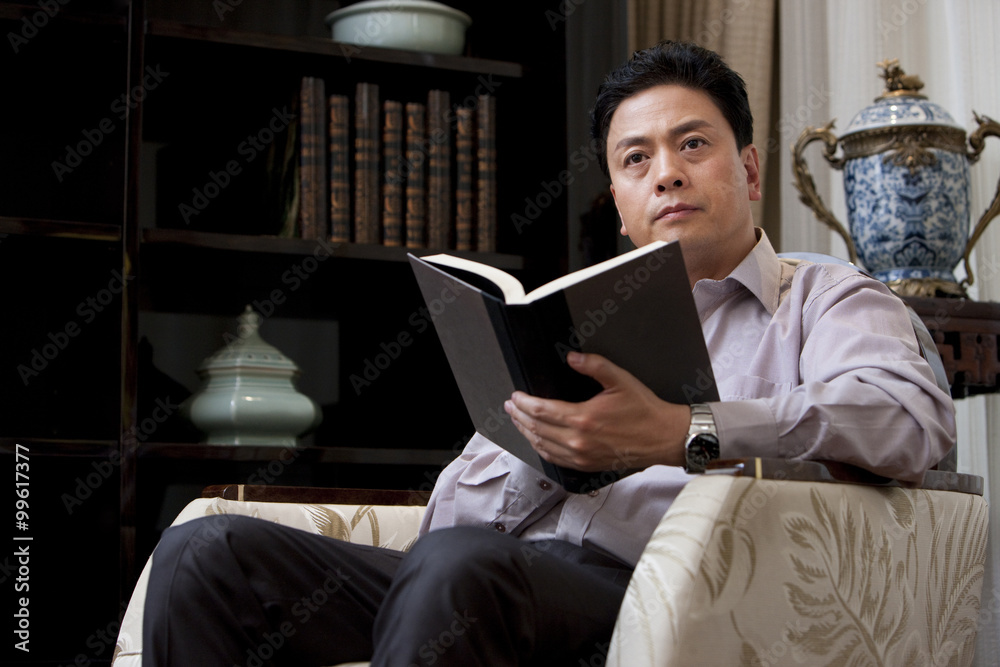 Mature man reading a book in study Mature man reading a book in study