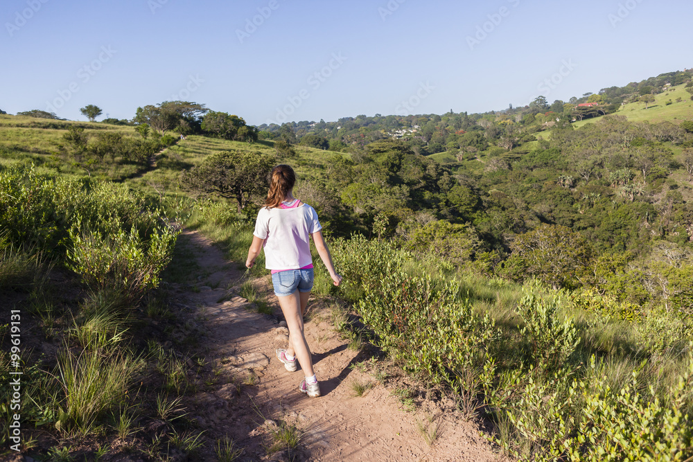 Girl Hiking Wilderness footpath trail rural landscape summer.