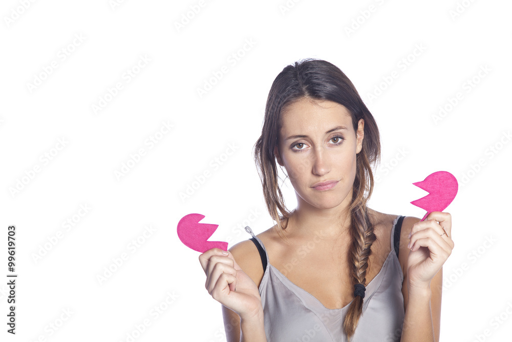 Beautiful sad young girl holding a broken heart. Concept of heartbreak. Isolated on white background Beautiful sad young girl holding a broken heart. Concept of heartbreak. Isolated on white background