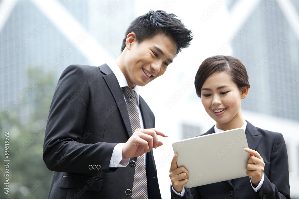 Happy business partners with digital tablet, Hong Kong Happy business partners with digital tablet, Hong Kong
