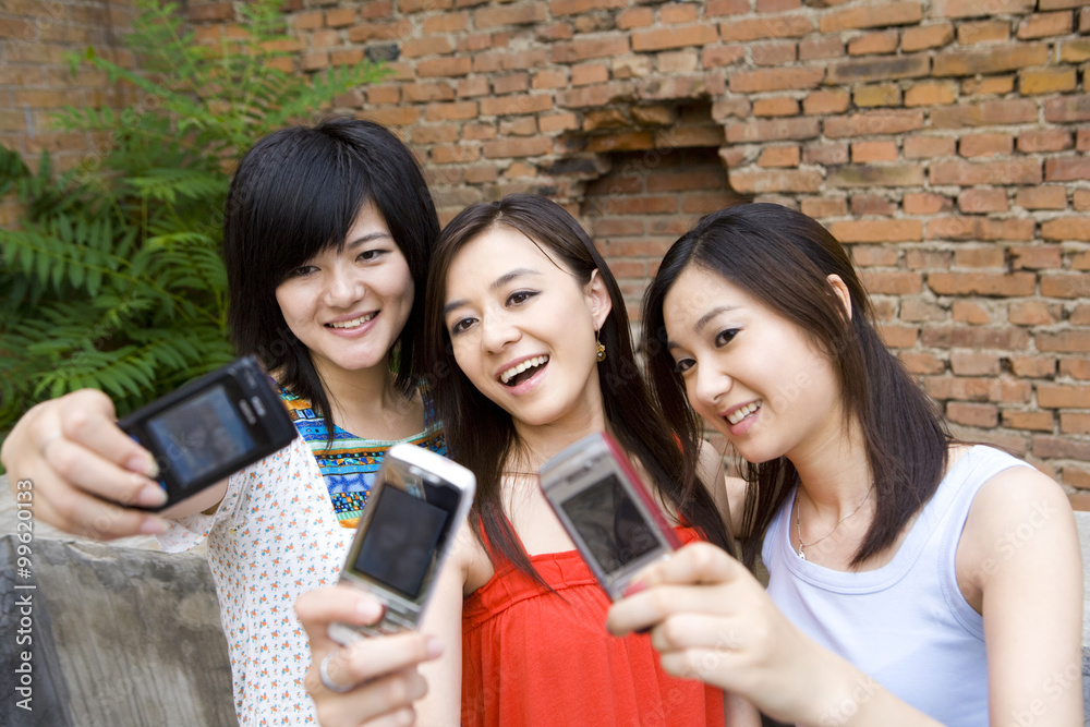 Friends taking photos with mobile phone Friends taking photos with mobile phone