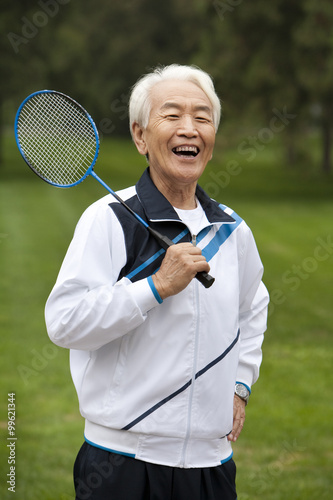Senior Man Holding Badminton Racket in a Park © Blue Jean Images
