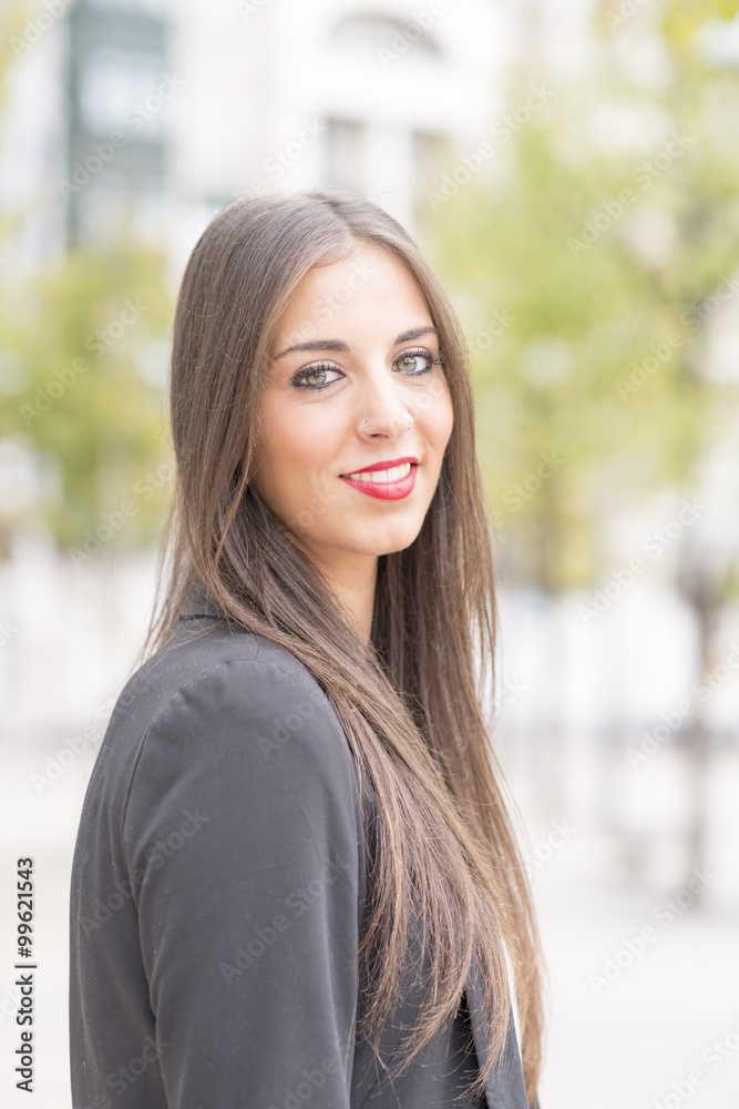 Smiling business woman looking at camera in the street. Smiling business woman looking at camera in the street.