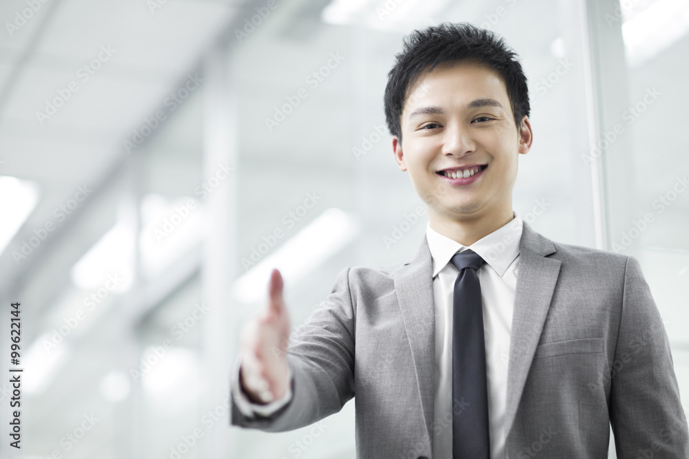 Young businessman extending hand for handshake Young businessman extending hand for handshake
