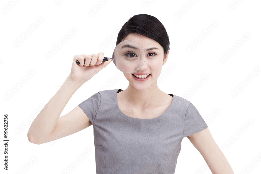 Young businesswoman looking through magnifying glass Young businesswoman looking through magnifying glass