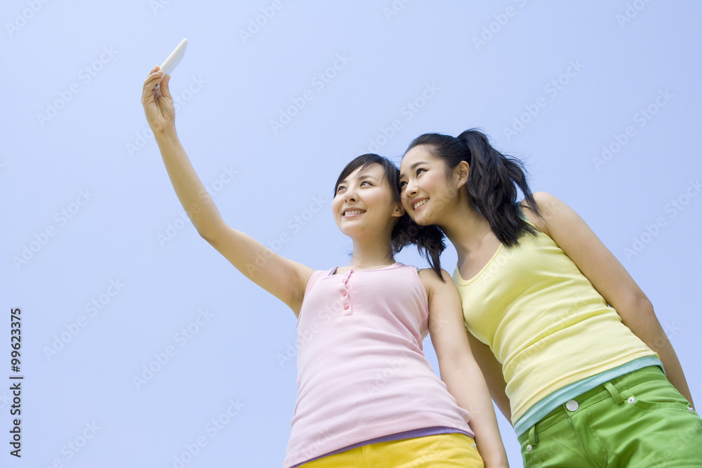 Two young women with a mobile phone Two young women with a mobile phone