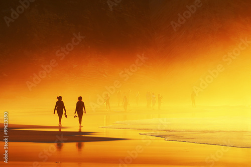couple of women walking on beach