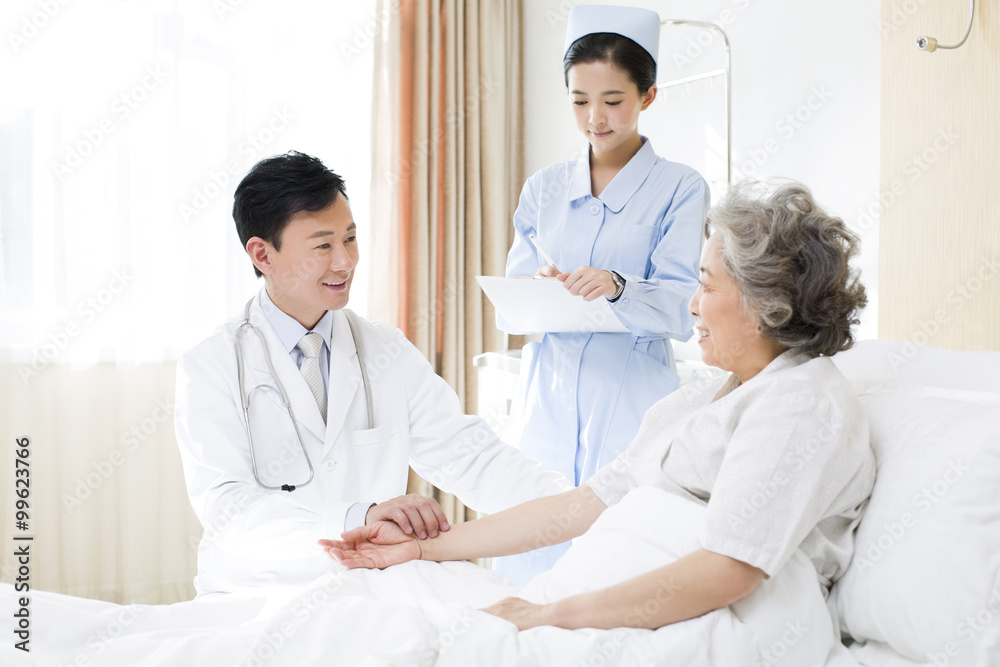 Male physician taking pulse of patient in hospital Male physician taking pulse of patient in hospital