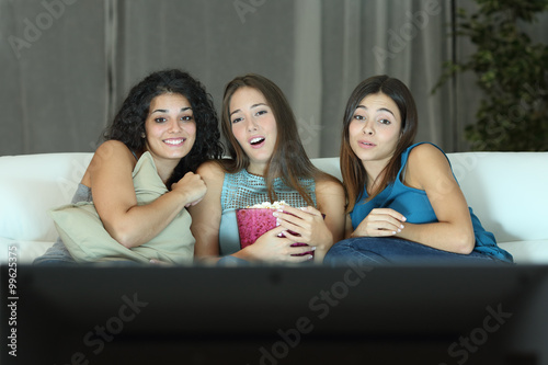 Three friends watching romantic movie on tv