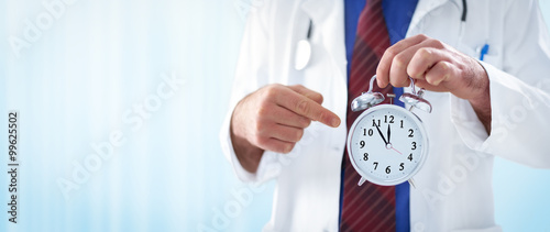 male doctor holding an alarm clock photo