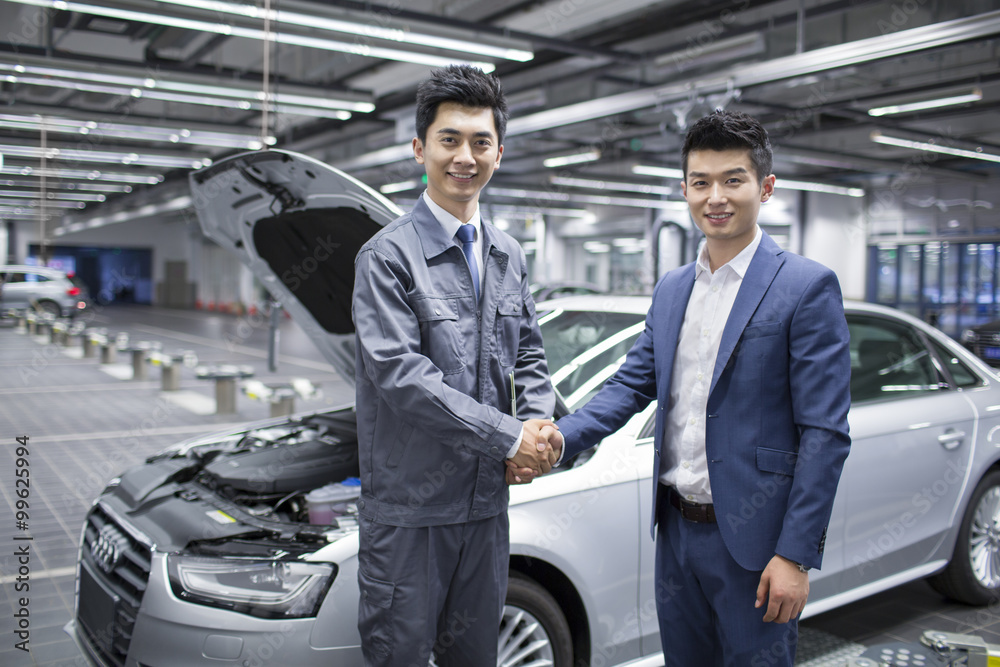Auto mechanic and car owner shaking hands Auto mechanic and car owner shaking hands
