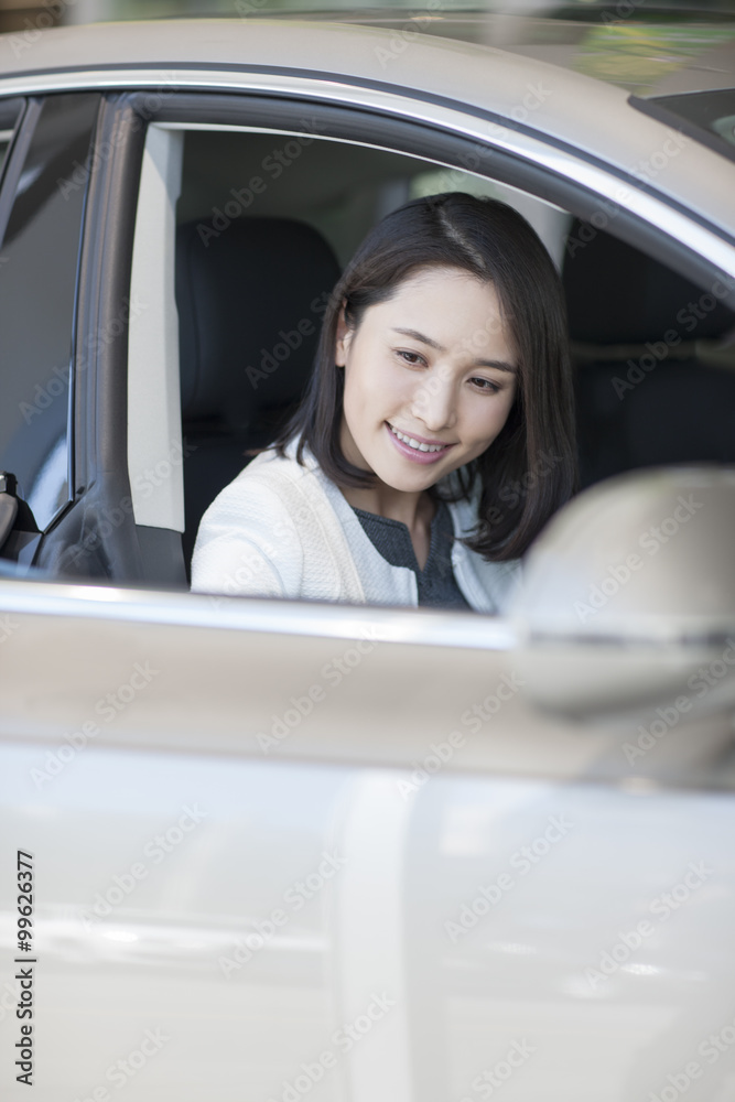 Young woman choosing car in showroom Young woman choosing car in showroom