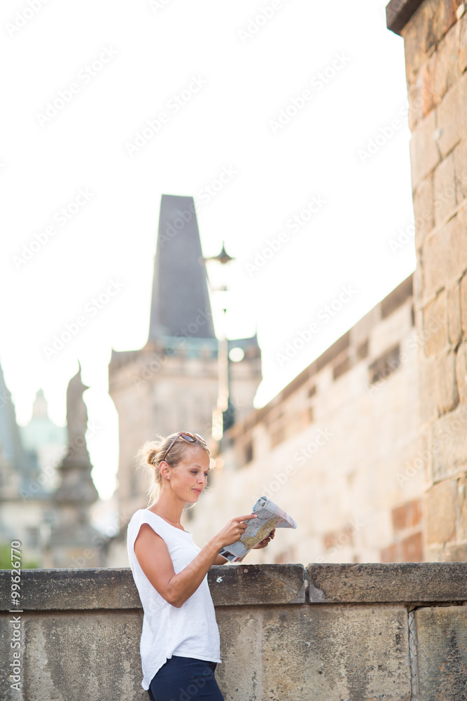 Pretty young female tourist studying a map, 