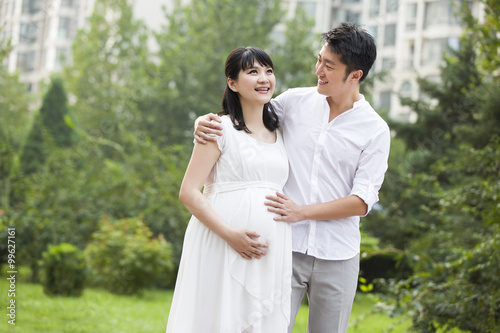 Expectant couple touching baby bump