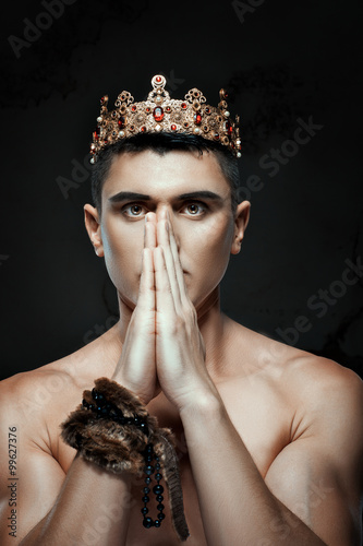 Man crown on his head to pray with folded hands.