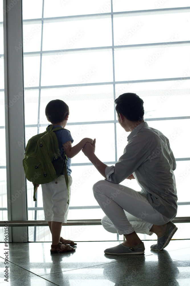 Father and son looking at view at the airport Father and son looking at view at the airport