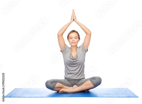 Fototapeta Naklejka Na Ścianę i Meble -  woman making yoga meditation in lotus pose on mat