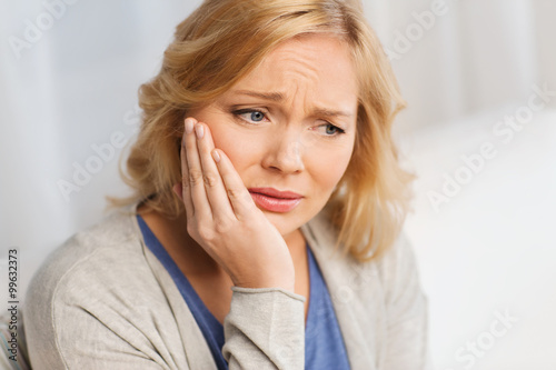 unhappy woman suffering toothache at home