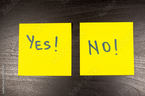 yes and no sticky note on wooden background