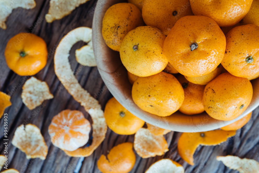 Still life of orange fruit in bowl on old wood background.
