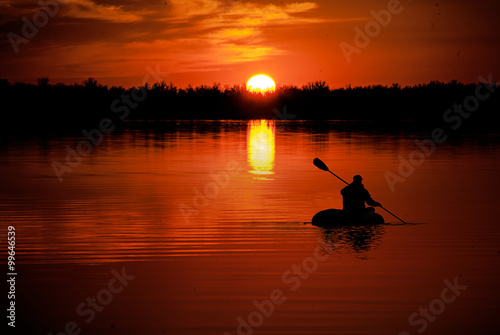 man in kayaking on Lake at sunset © Vasilev Evgenii