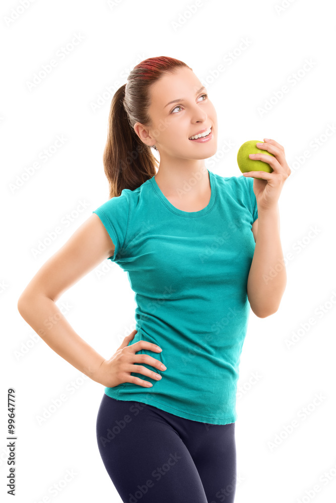 Smiling young girl in fitness clothes holding an apple Smiling young girl in fitness clothes holding an apple