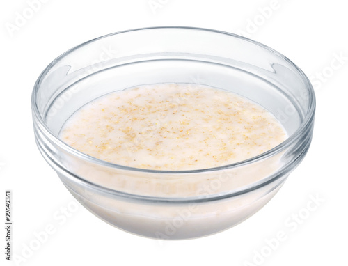 Oatmeal in a glass bowl on white background