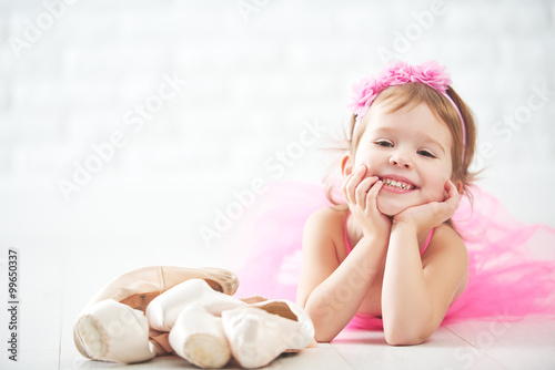 little child girl dreams of becoming  ballerina with ballet shoe