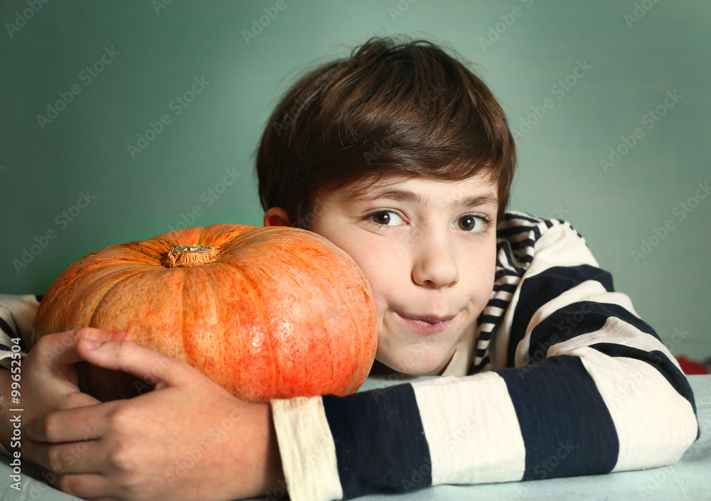 Fototapeta premium boy with big orange pumpkin close up portrait