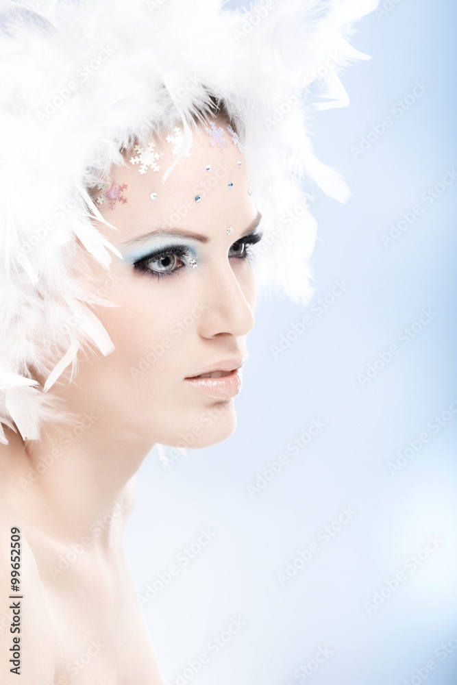 Winter beauty in feather hat daydreaming